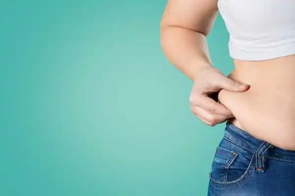Image of woman pinching her love handles to show weight gain Salford Priors